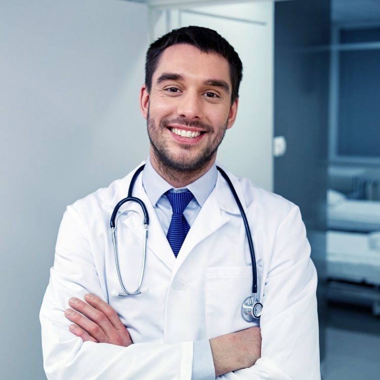 smiling doctor with stethoscope at hospital